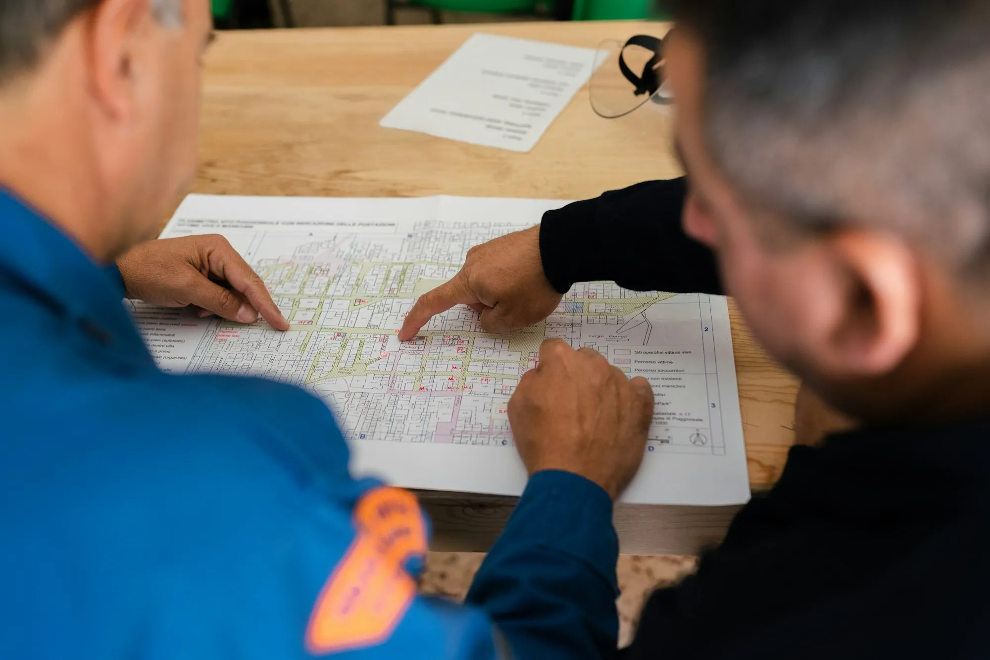 Two engineers marking up a site plan on a table